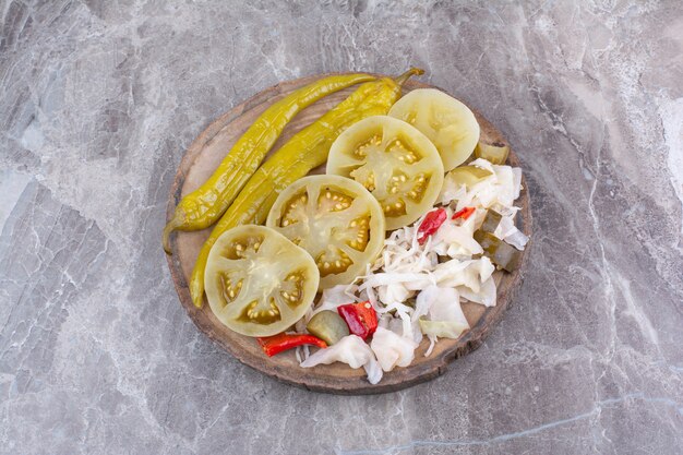 Variété de cornichons hachés sur pièce en bois.