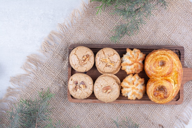 Variété de délicieux cookies sur planche de bois.