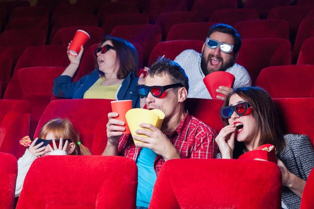 Une variété d'émotions humaines d'amis tenant un cola et du pop-corn au cinéma.