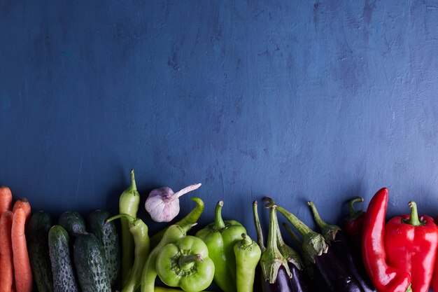 Variété de légumes au bas du tableau bleu.