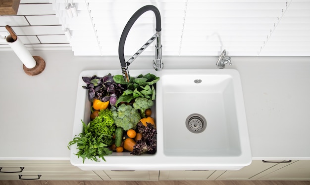 Photo gratuite variété de légumes dans l'évier de cuisine moderne de près.