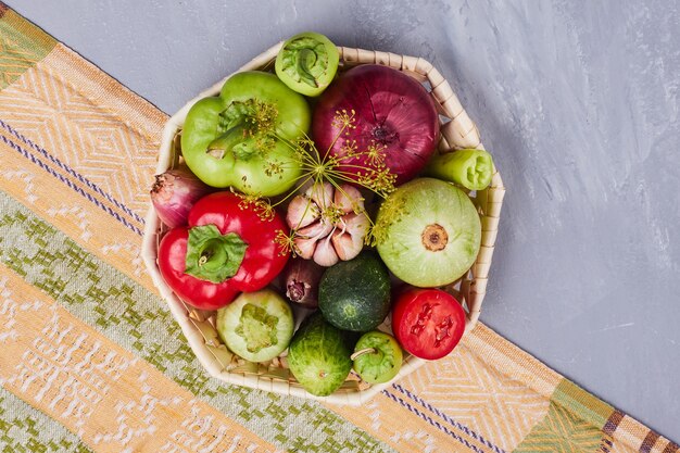 Variété de légumes dans un panier en bambou, vue du dessus.