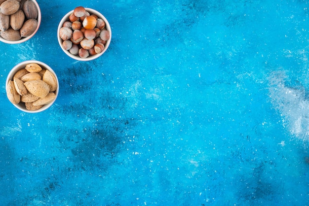 Une variété de noix dans des bols , sur la table bleue.