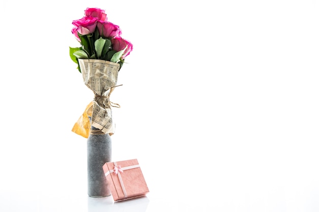 Photo gratuite vase minimaliste de roses et petit cadeau