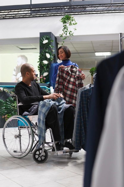 Photo gratuite vendeur montrant l'homme en chemise de fauteuil roulant