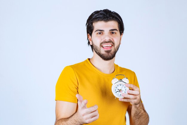 Un vendeur tenant et faisant la promotion du réveil.