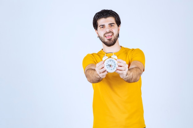 Un vendeur tenant et faisant la promotion du réveil.