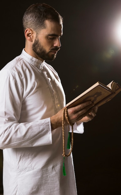 Événement du Ramadam et homme arabe debout avec coran et chapelet