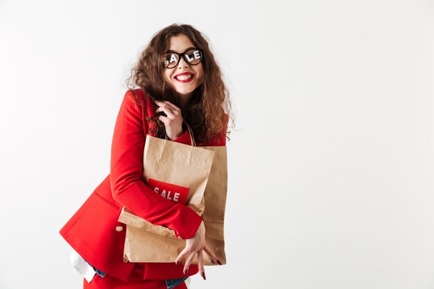 Vente attrayante femme tenant des sacs en papier isolé sur blanc