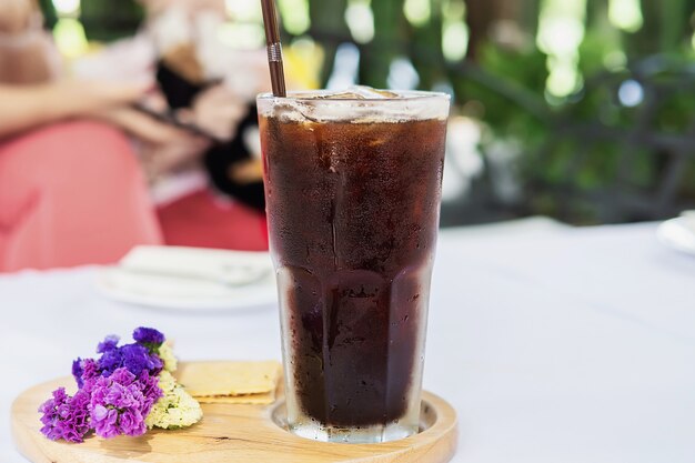 Verre americano froid sur la table de recouvrement en tissu blanc - concept de boissons relaxantes froides