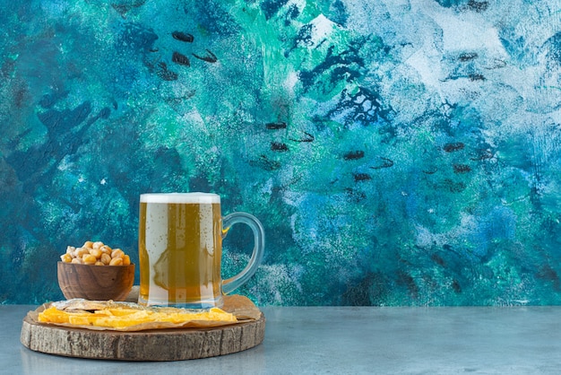 Un verre de bière et apéritifs à bord sur bleu.