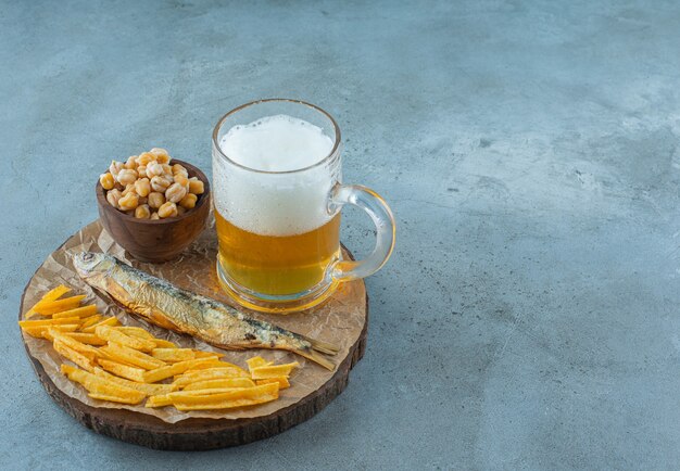 Un verre de bière et apéritifs à bord sur bleu.