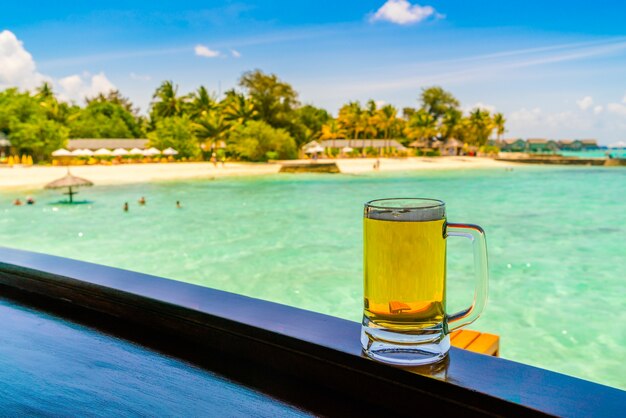 Un verre de bière avec une belle île des Maldives tropicales.