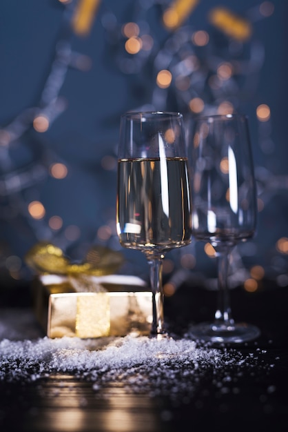 Verre avec boisson à bord près de la neige et du présent