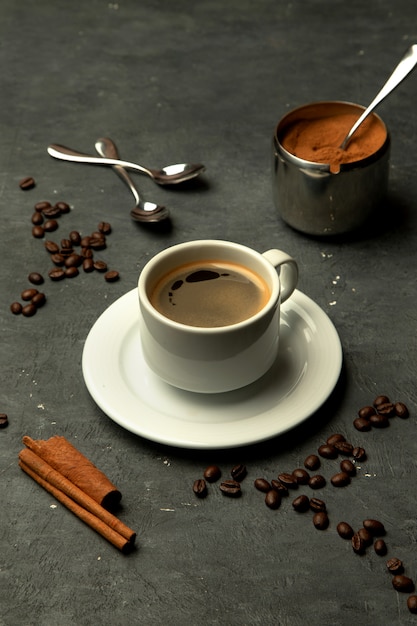 Verre de café americano sur fond gris décoré de grains de café