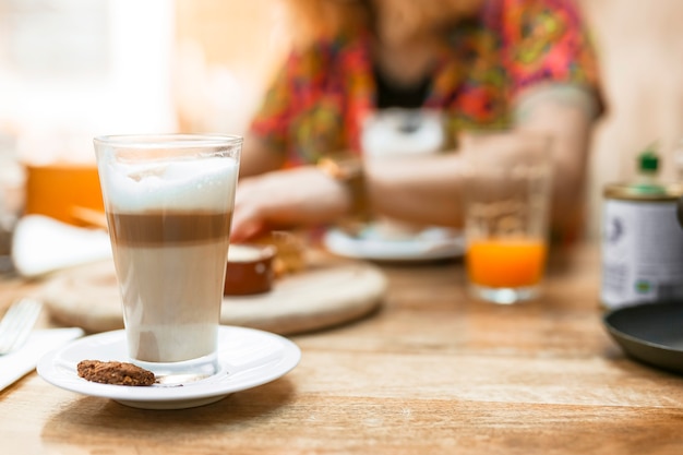 Verre à café multicouche avec biscuit sur une soucoupe