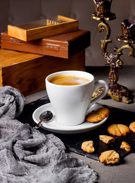 Un verre de café servi avec des biscuits