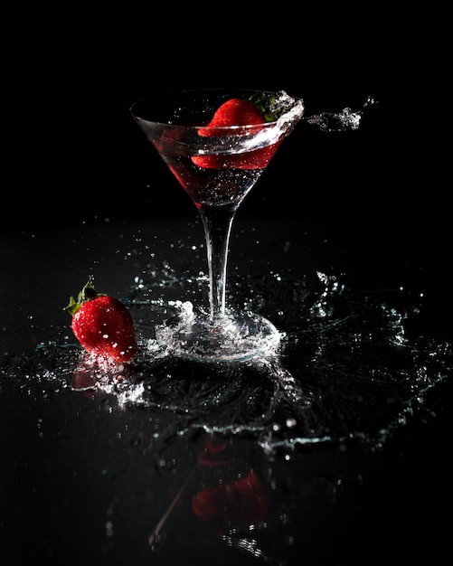 Verre de cocktail aux fraises sur fond noir