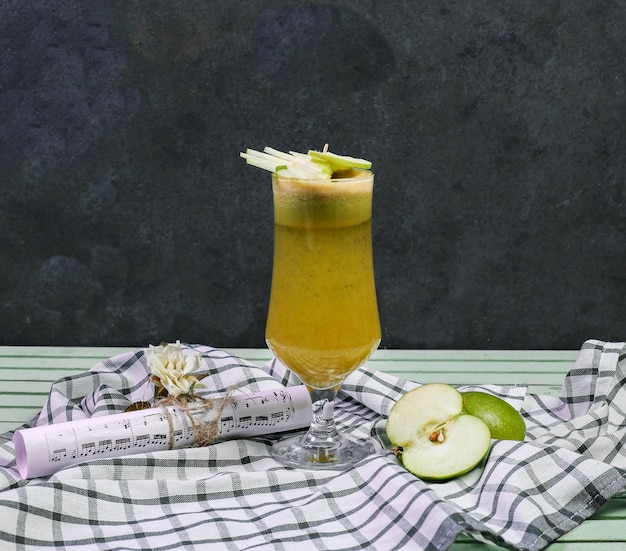 Un verre de cocktail de jus de pomme sur un morceau de bois.