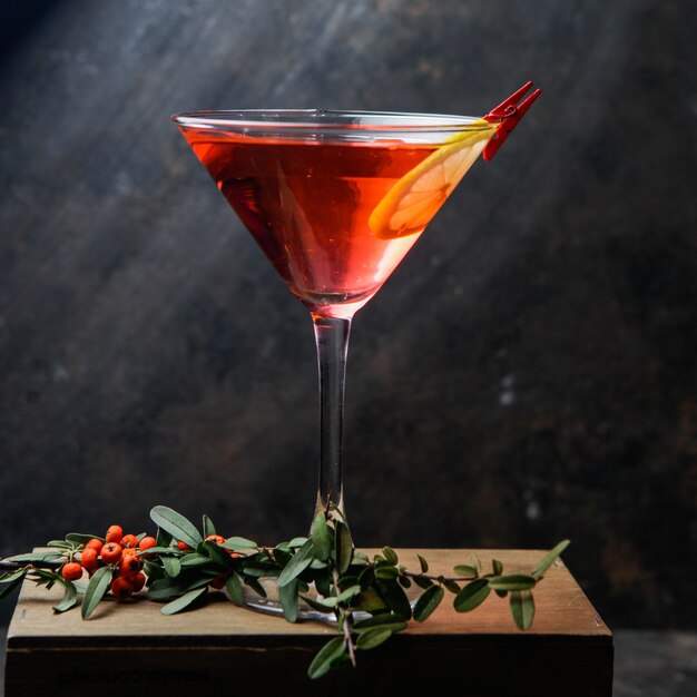 Verre à cocktail martini rouge avec citron et fruits rouges