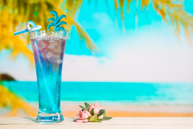 Verre de délicieuse boisson bleue et fleur rose