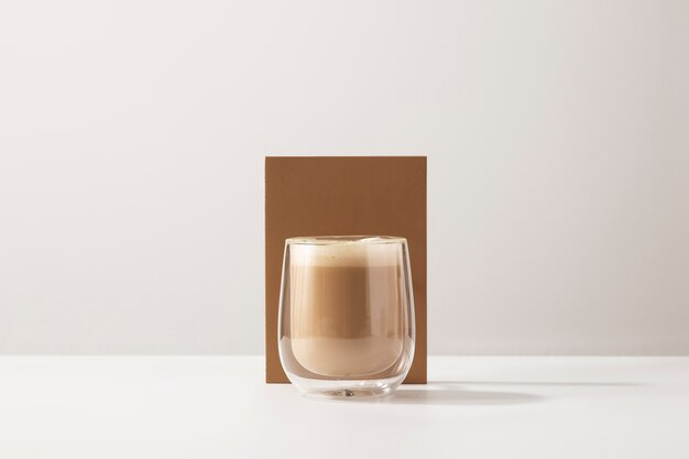 Verre avec un délicieux café et fond blanc