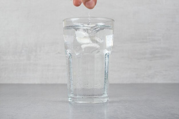 Un verre d'eau froide pure sur une surface grise