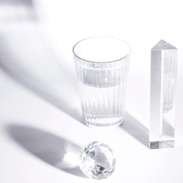 Verre d&#39;eau; prisme; diamant étincelant sur fond blanc