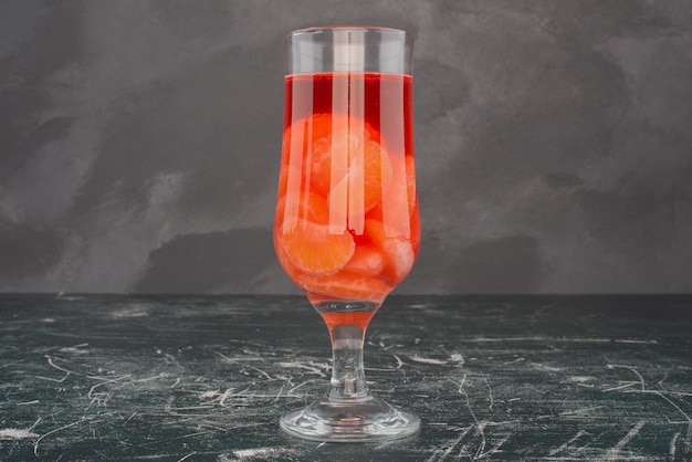 Photo gratuite verre de jus de mandarine sur table en marbre.