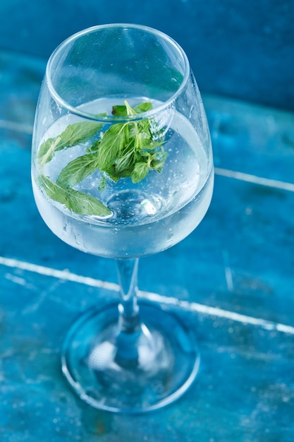 Photo gratuite un verre de jus à la menthe sur une surface bleue