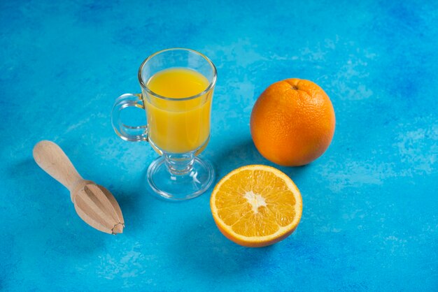 Un verre de jus d'orange sur fond bleu.