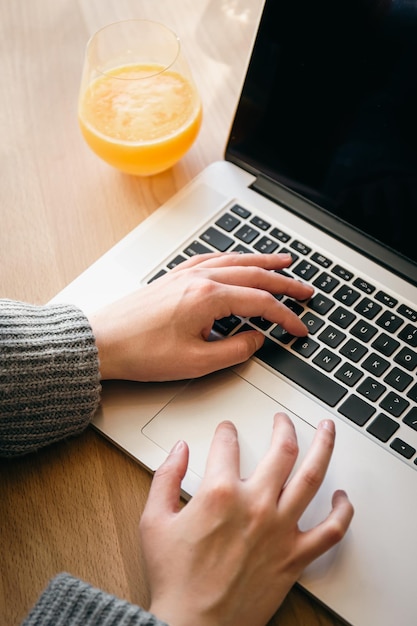 Un verre de jus d'orange et un ordinateur portable le concept de travail et d'étude