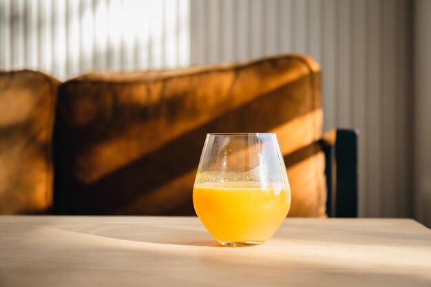 Un verre de jus d'orange sur la table au petit matin ensoleillé