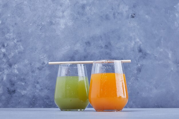 Un verre de jus d'orange avec un verre de jus de pomme.