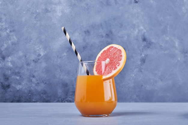 Un verre de jus de pamplemousse au milieu.