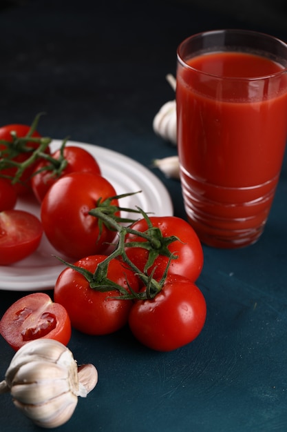 Un verre de jus de tomate avec des légumes sur la table.