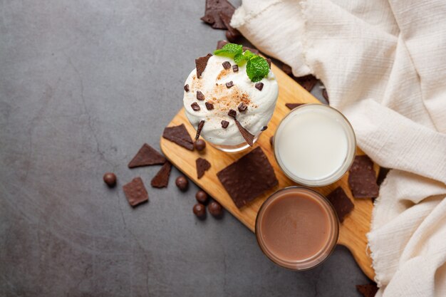 Verre de lait au chocolat sur la surface sombre.