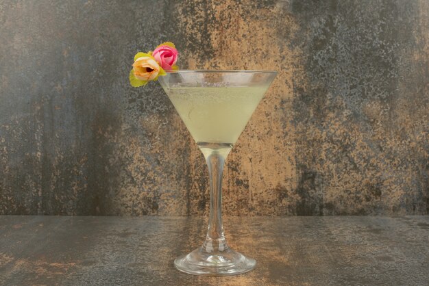 Un verre de limonade juteuse et de roses sur une surface en marbre.