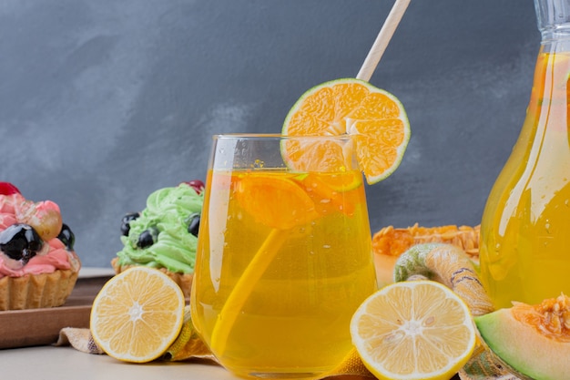 Un verre de limonade et de petits gâteaux crémeux sur table.