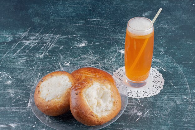 Un verre de petits pains au fromage et limonade sur table en marbre.