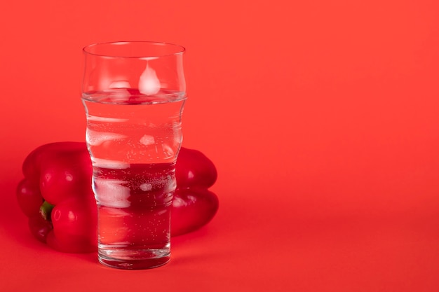 Verre avec poivron rouge et fond rouge