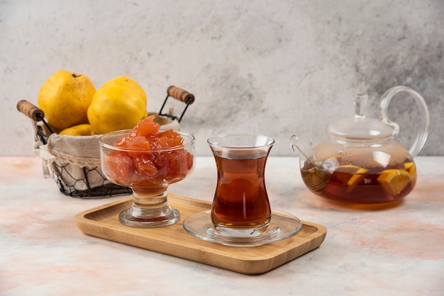 Verre De Thé, Confiture Et Coings Sur Plaque De Bois.