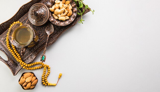 Verre à thé avec noix et perles sur plateau