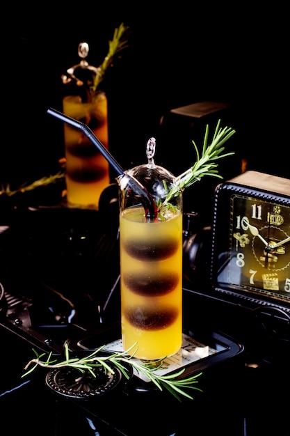 Photo gratuite verre unique de cocktail bicolore garni de rosemarine
