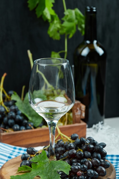Un verre de vin blanc avec des fruits à part.