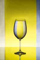 Photo gratuite verre à vin avec de l'eau sur fond gris et jaune