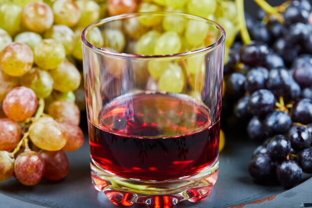 Un verre de vin avec une grappe de raisin vert.