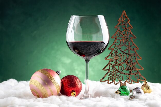 Verre à vin vue de face et ornements de Noël sur fond vert