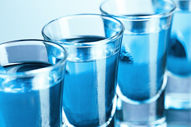 Verre de vodka avec glace sur bleu