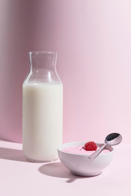 Photo gratuite verre avec yougurt à la framboise sur le bureau